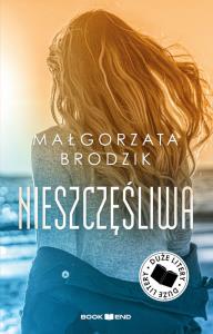 Nieszczęśliwa. Duże Litery. Autor: Małorzata Brodzik. Dobreksiazki.pl Okładka książki Nieszczęśliwa. Duże Litery